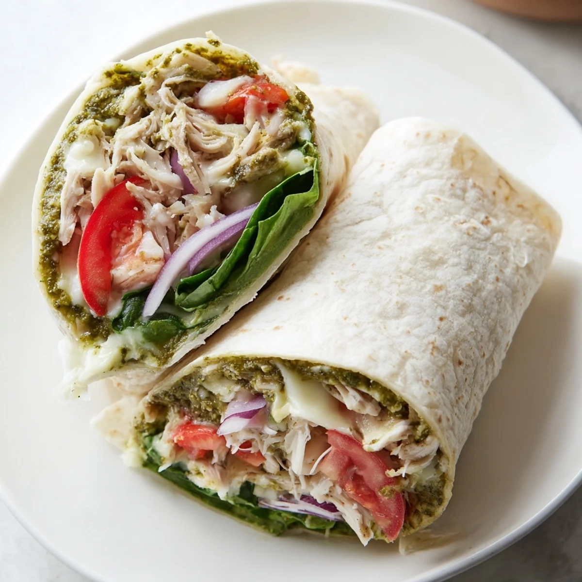 Pesto Chicken Wrap, filled with savory chicken, mozzarella, fresh veggies, ready to eat!