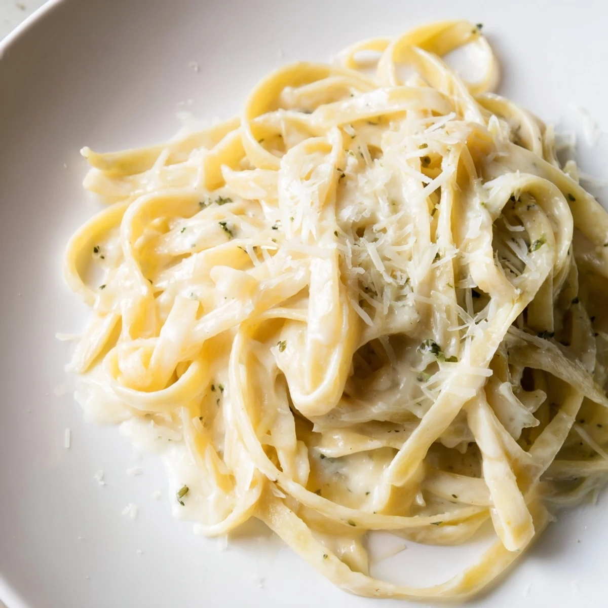 Steaming bowl of homemade Roasted Garlic Cream Pasta, featuring a luscious sauce and freshly grated cheese.