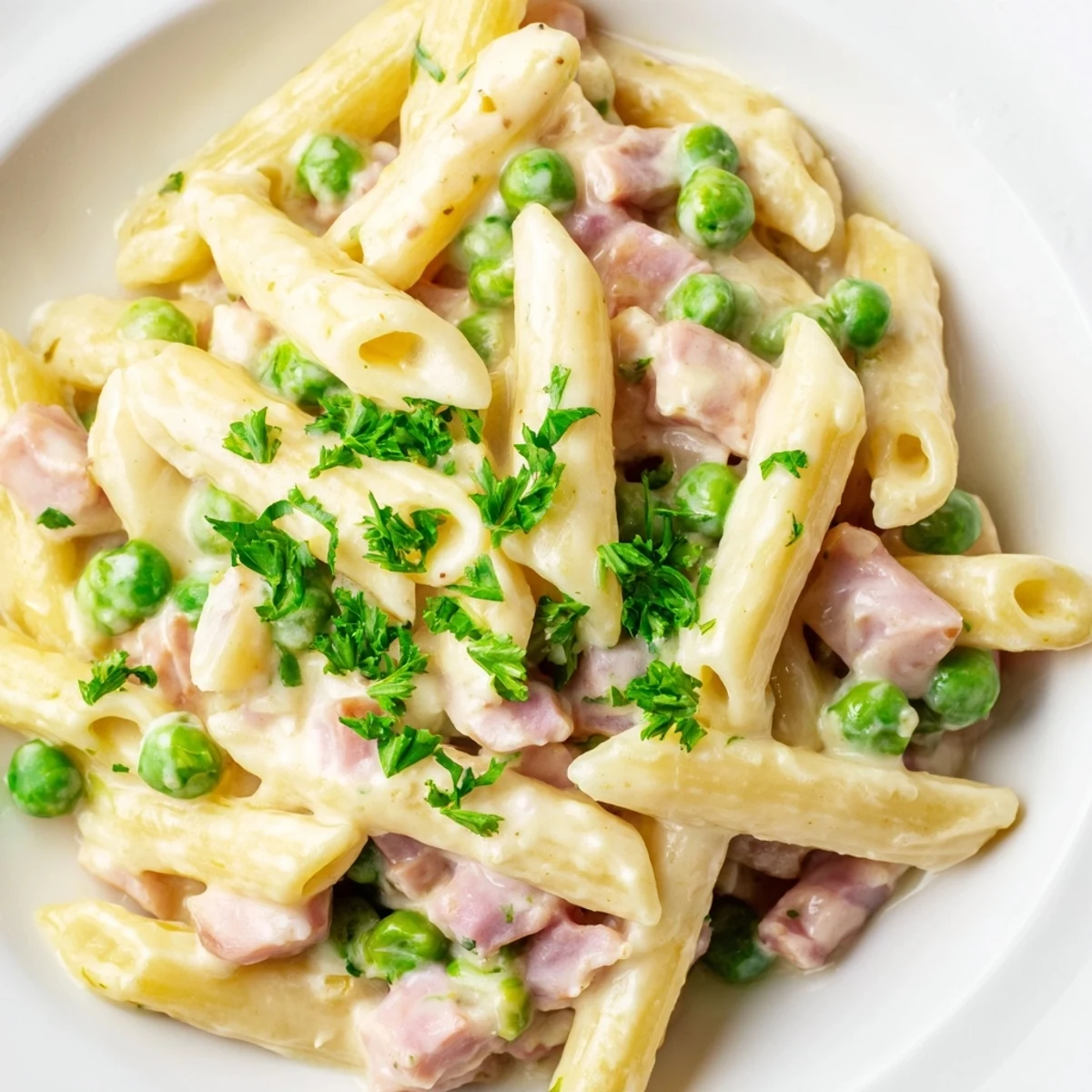 Spring Pea & Ham Pasta features tender penne tossed in a rich cream sauce with bright peas and hearty ham.