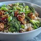Individual serving of Sweet and Spicy Turkey Broccoli Bowls garnished with sesame seeds and fresh green onion.