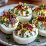 Spicy jalapeño popper deviled eggs with cream cheese, crispy bacon, and diced jalapeños make a bold, creamy appetizer.  
