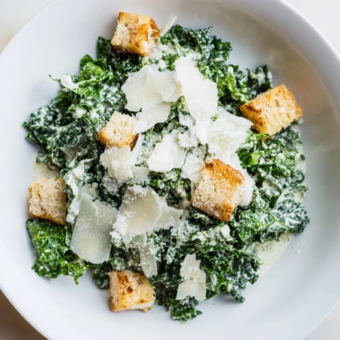A close-up shot of a creamy, flavorful Kale Caesar Salad, ready to be enjoyed immediately.