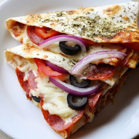 Folded Tortilla Pizza Wrap sizzling in a skillet, showing a cheesy interior with red onion and olives visible.