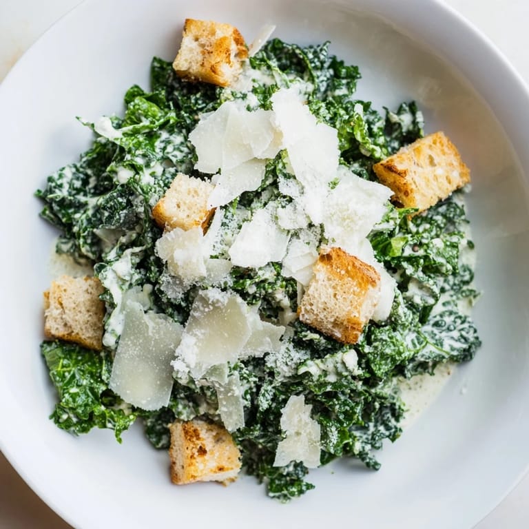 A close-up shot of a creamy, flavorful Kale Caesar Salad, ready to be enjoyed immediately.