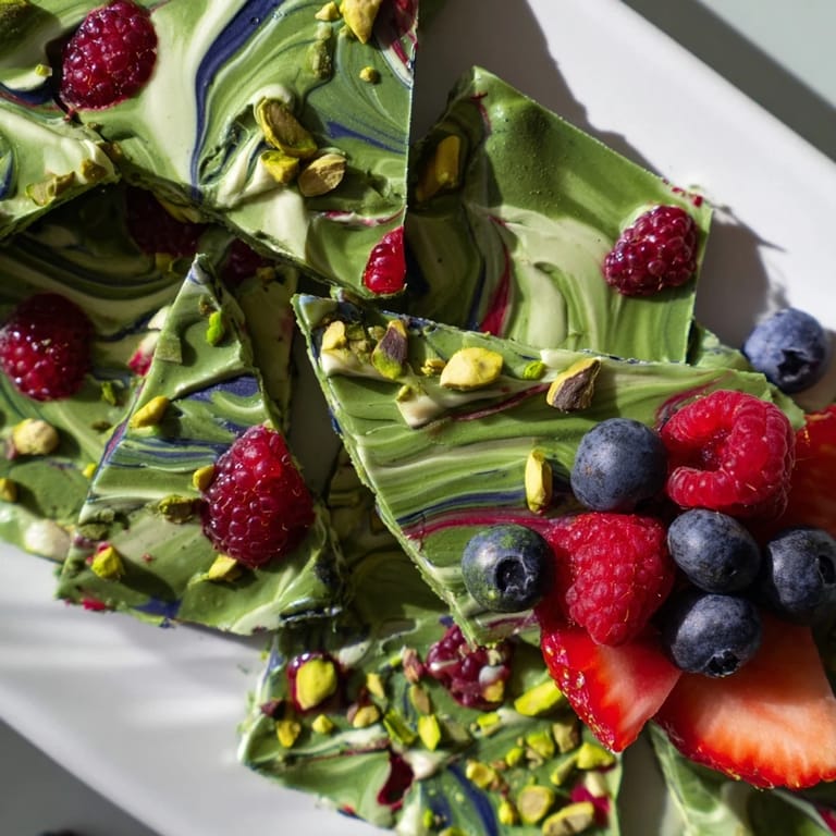 Beautifully marbled Frozen Yogurt Bark, layered with pistachio cream and topped with vibrant berries.