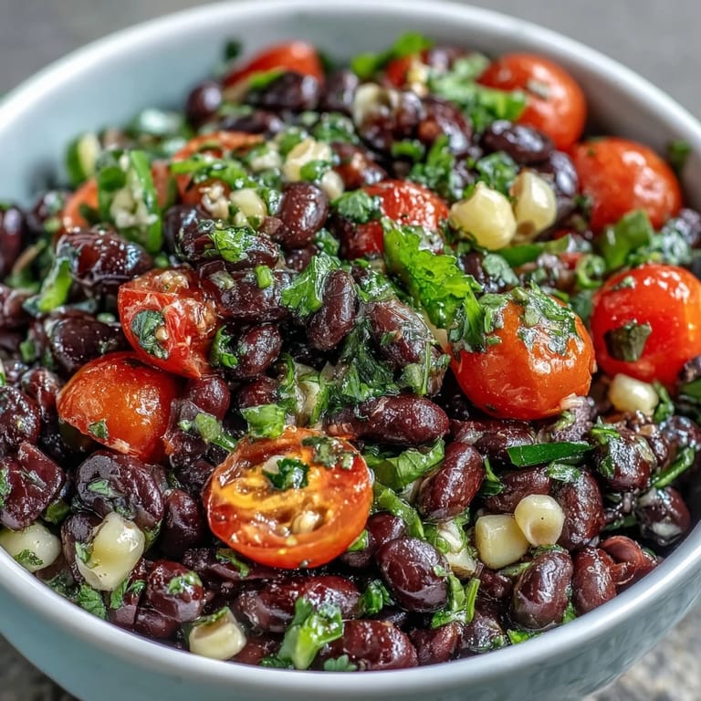 Close-up view of Cowboy Caviar salad, highlighting fresh cilantro, red onion, and cherry tomatoes in a vibrant Tex-Mex appetizer.