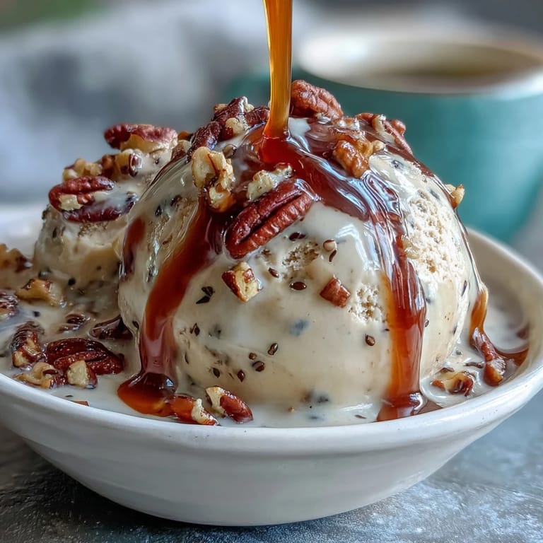 Crushed almonds top a cup of Hojicha Affogato, featuring steaming hojicha tea poured over smooth vanilla ice cream.
