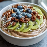 Creamy Hojicha Smoothie Bowl topped with berries, sliced kiwi, and crunchy granola makes a nourishing breakfast.