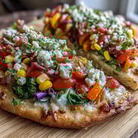 Vibrant St. Patrick's Day Rainbow Veggie Flatbread Pizza with fresh mozzarella and feta.